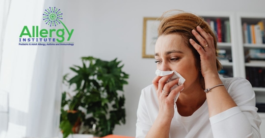 woman blowing nose due to allergies